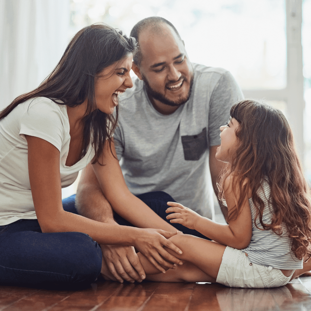 Hier sitzt eine Familie mit einem Kind auf dem Boden. Die kleine Tochter spricht und lacht mit der Mutter. der Vater hat auch ein lächeln auf den Lippen. Vielleicht reimen sie auf Englisch?