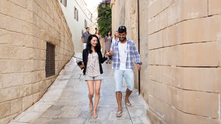 Sapziergang auf Malta Auf dem Bild befinden sich zwei Personen auf einem Date in Malta. Sie genießen einen Spaziergang durch die Gassen.