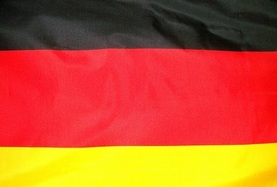 La imagen muestra la bandera alemana desde muy cerca. Se aprecian los colores negro, rojo y dorado típicos de Alemania.