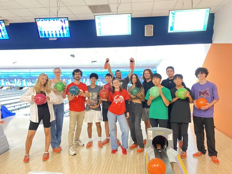 Sprachcaffe-Schüler/innen posieren mit Bowlingkugeln bei einer lustigen Indoor-Aktivität.
