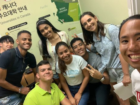 Eine bunt gemischte Gruppe von Sprachcaffe-Schülerinnen und -Schülern lächelt gemeinsam in einem kanadischen Klassenzimmer.