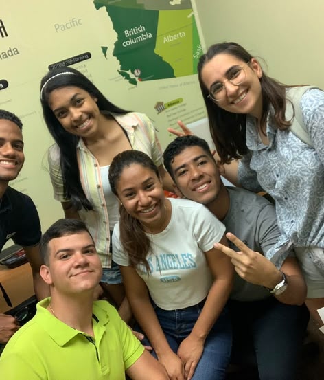 Eine bunt gemischte Gruppe von Sprachcaffe-Schülerinnen und -Schülern lächelt gemeinsam in einem kanadischen Klassenzimmer.