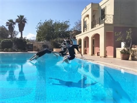 Viele wissen gar nicht, dass in Malta auch Englisch gesprochen wird und sich eine Reise dorthin zum Englisch Rechtschreibung lernen durchaus lohnt. Hier siehst du unseren Sprachcaffe Campus mit Pool im wunderschönen Malta.