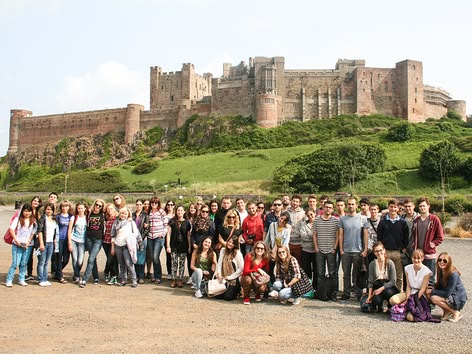 Große Schülergruppe vor einer historischen englischen Burg während einer Sprachcaffe-Reise.