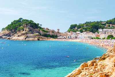 Eine wunderschöne Küste in Spanien bei gutem Wetter. Im Hintergrund befindet sich eine kleine Stadt im spanischen Stil.