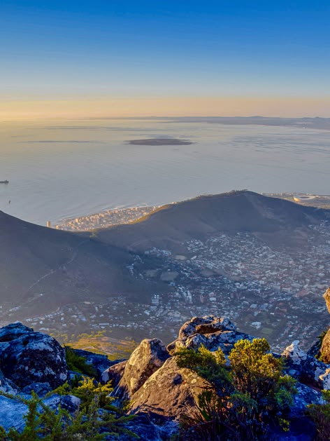 Panoramic view of Cape Town, South Africa, from Table Mountain with Lion's Head and the coastline below at sunrise.