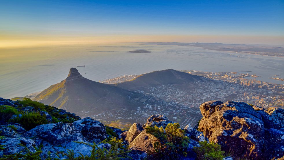 Panoramablick auf Kapstadt, Südafrika, vom Tafelberg mit dem Lion's Head und der Küste darunter bei Sonnenaufgang.