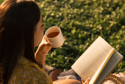 Dziewczyna pijąca kawę i czytająca książkę po angielsku